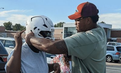 Kansas City Chiefs offensive lineman Orlando Brown helps youth football player find a helmet that fits him